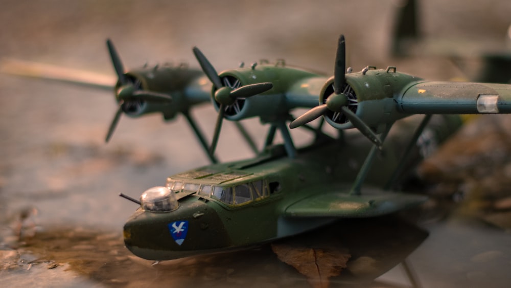 a green model airplane sitting on top of a table