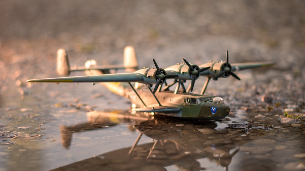 a toy airplane sitting on top of a puddle of water