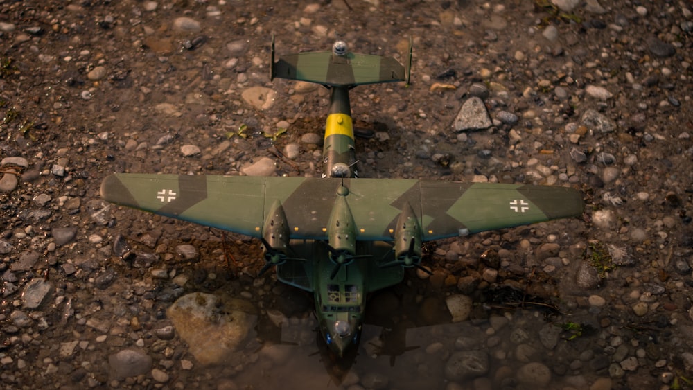 a military plane sitting on top of a dirt field