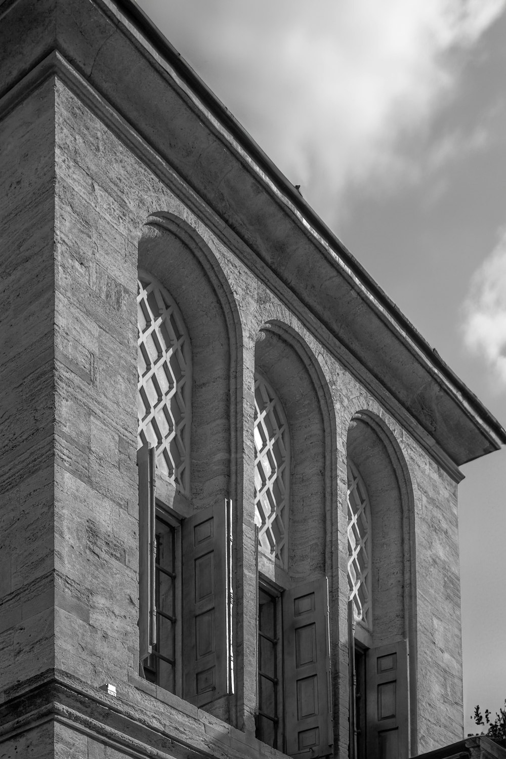 a black and white photo of a building with three windows