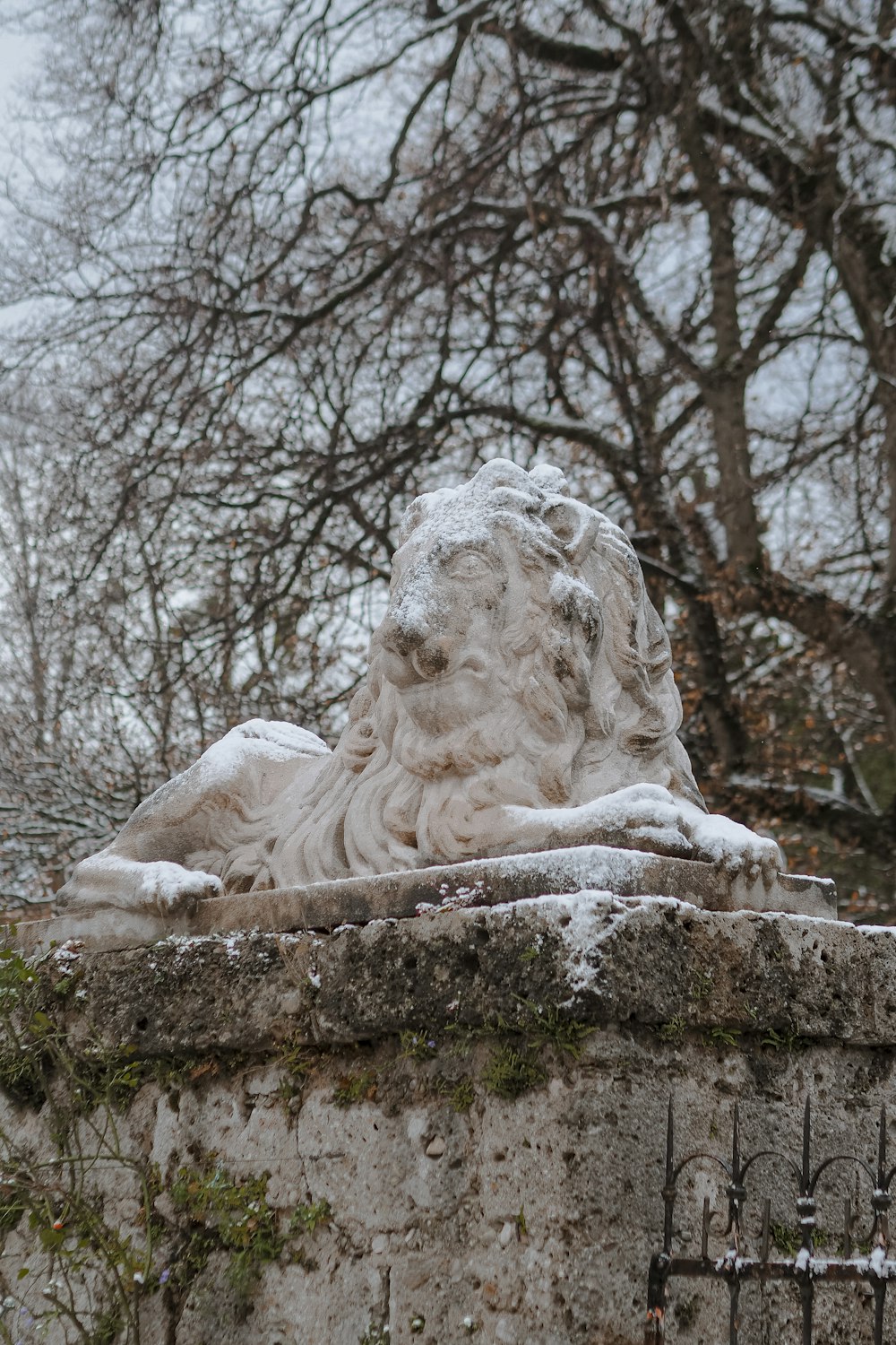 a statue of a lion is covered in snow
