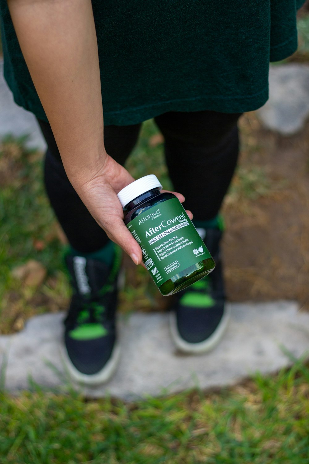 a person holding a bottle of green liquid