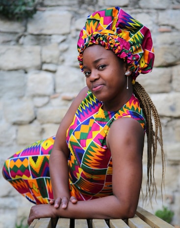 a woman sitting on top of a wooden bench