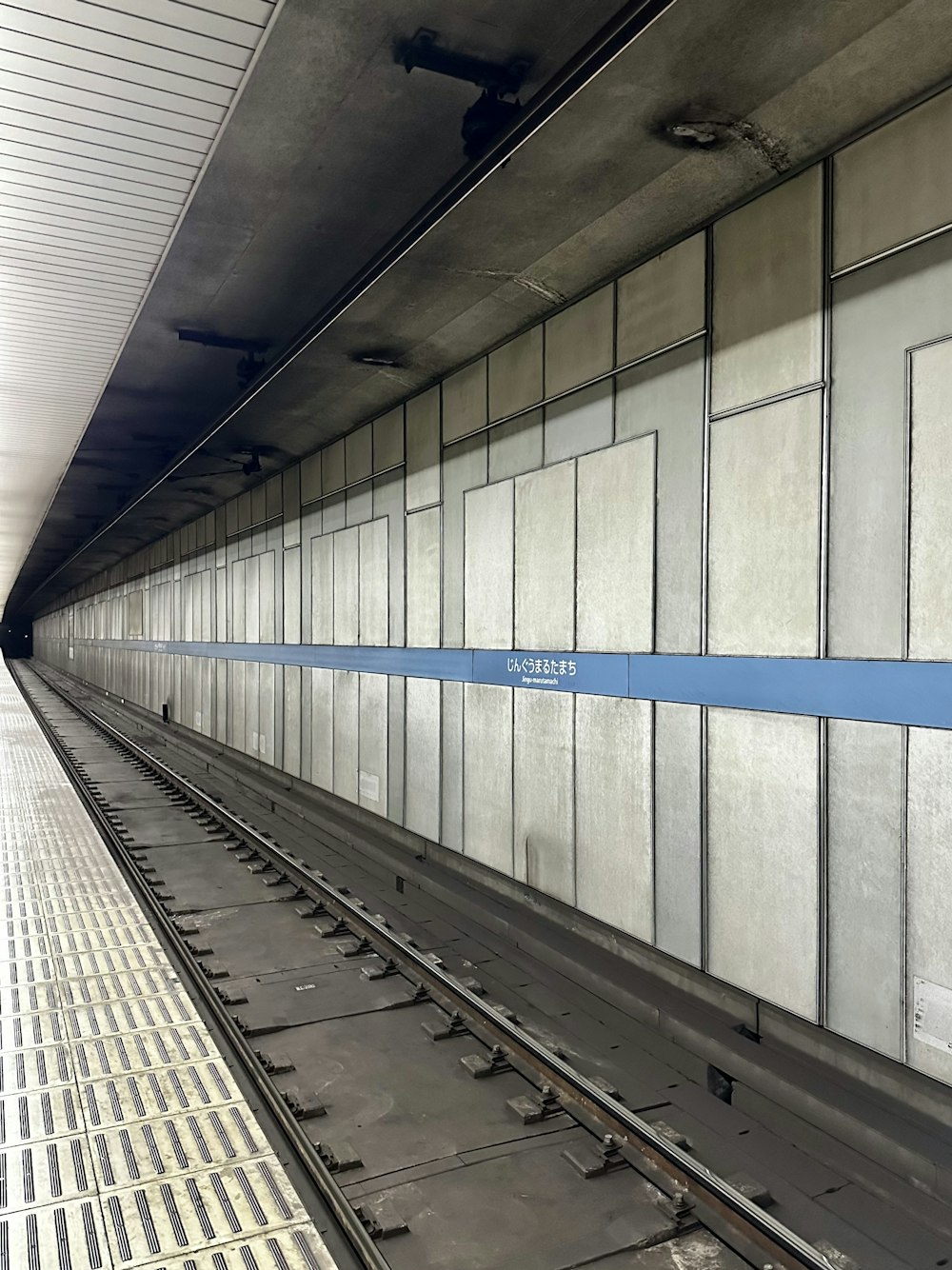 a subway station with a blue line on the wall