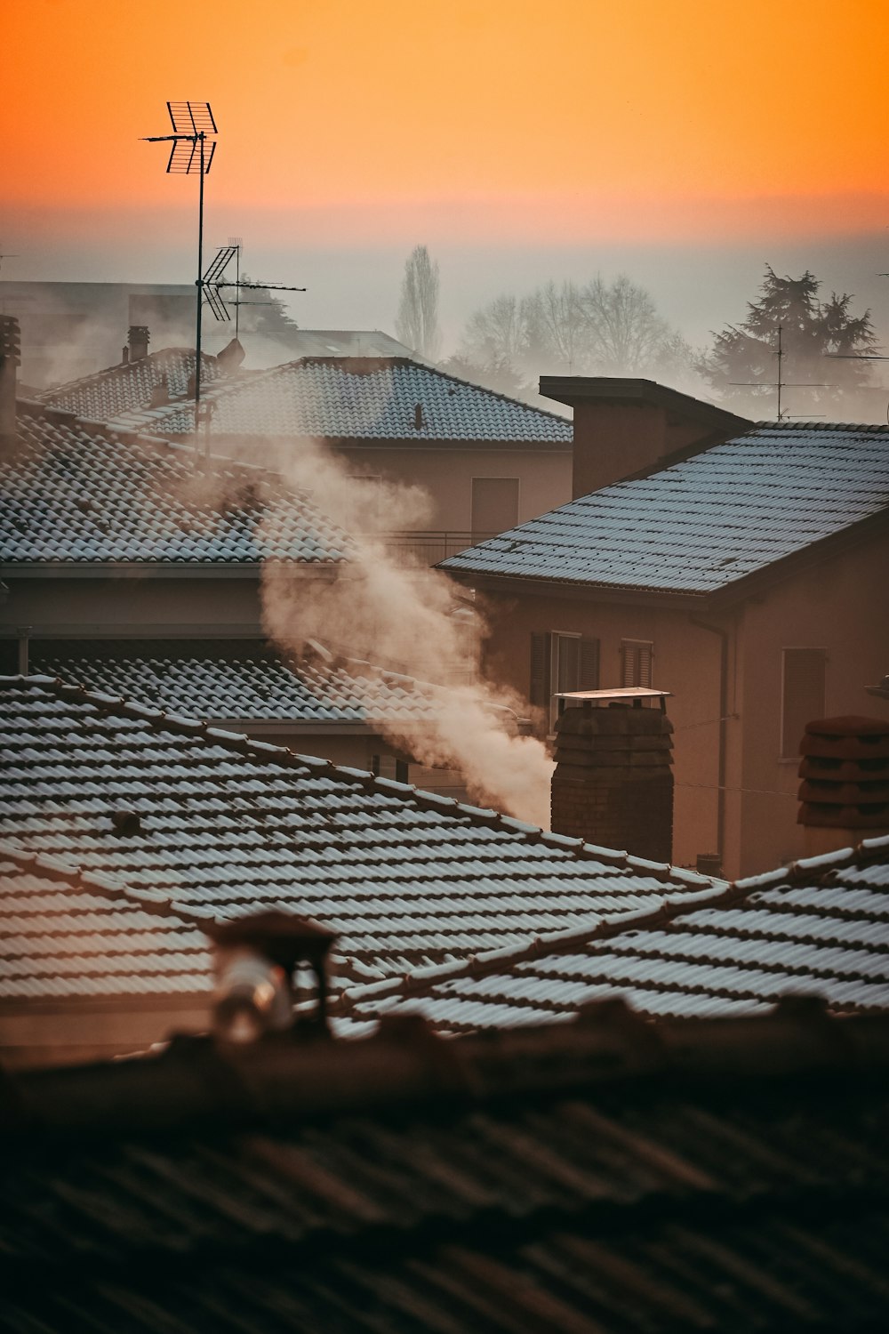 fumaça saindo de uma chaminé em cima de um telhado