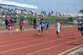 A group of athletes practicing sprinting on a track.