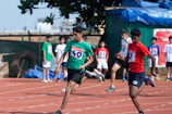 Youth athletes sprinting on a track, faces lit with competitive spirit.