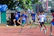 Athlete checking map mid-orienteering race, focused and determined.