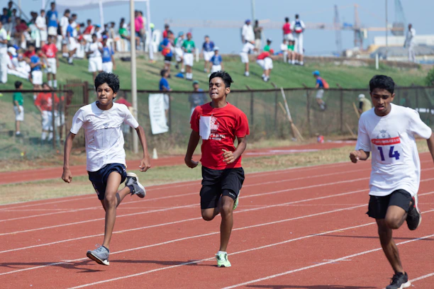 A group of athletes training together on a sunny outdoor track.