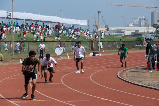 A group of visually impaired athletes smiling and preparing for a race outdoors