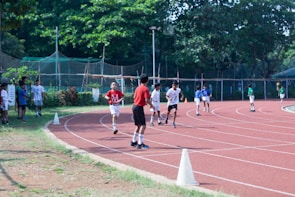 Kids laughing as they race in a colorful sack race on the grassy field.