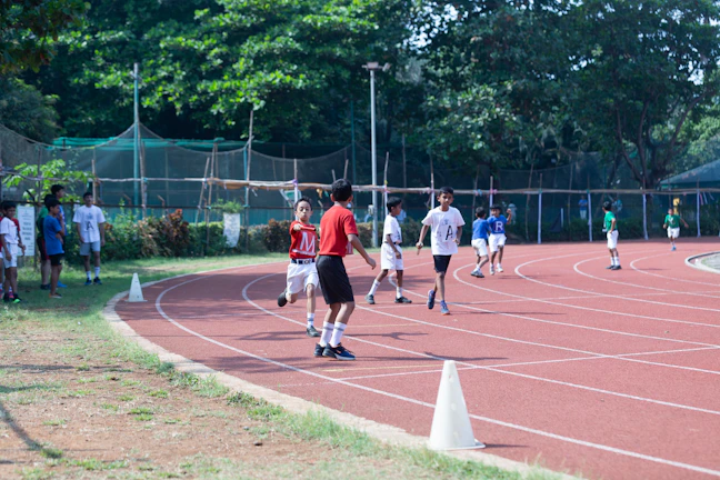 Kids lined up ready for a fun relay race with soccer balls.