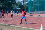 A diverse group of kids running together on a track, embodying energy and teamwork.