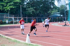 a group of young men running around a track