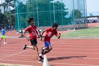 a couple of kids running around a track