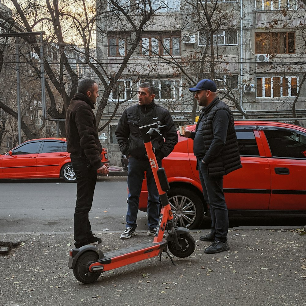 a group of men standing around a scooter