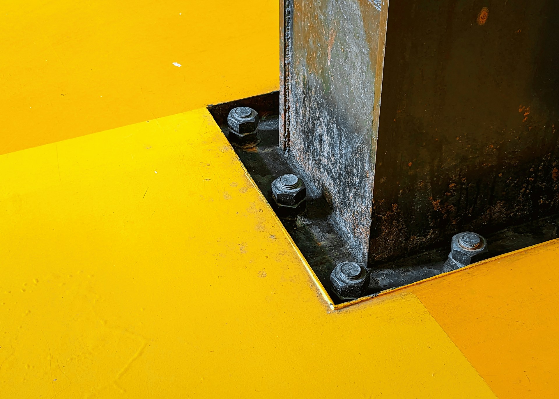a yellow and black floor with a metal pole