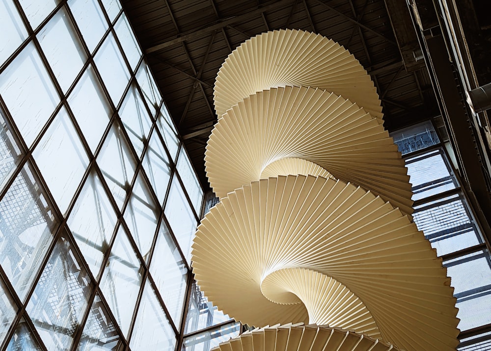 a tall sculpture in front of a window in a building