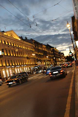 Solar street lights illuminating a busy municipal road at dusk.