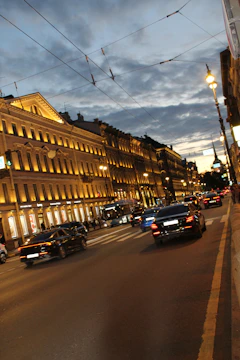 Solar street lights illuminating a busy municipal road at dusk.