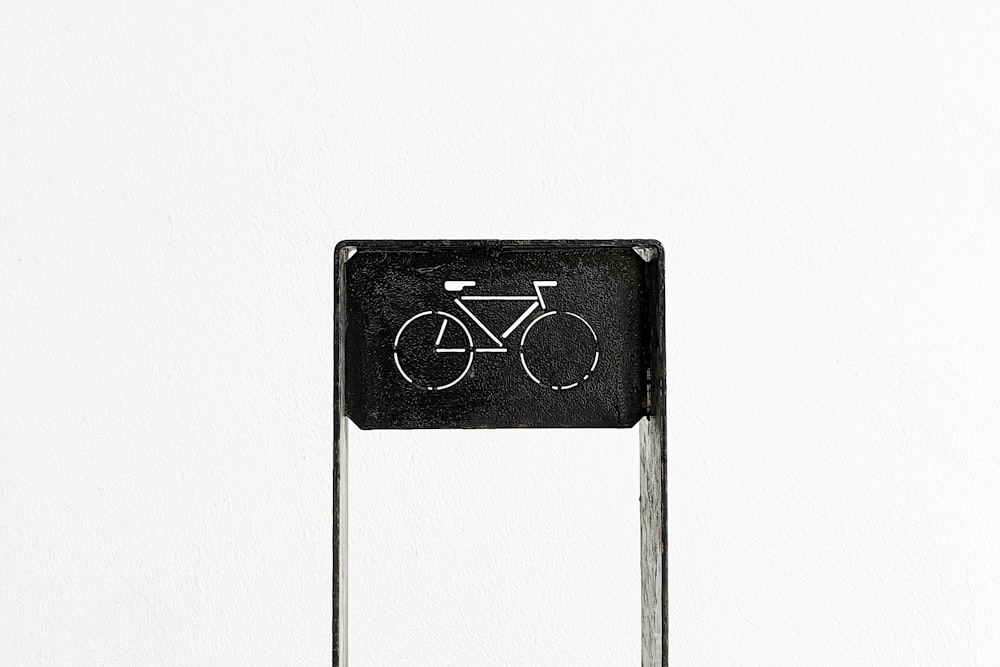 a black and white photo of a sign with a bicycle on it