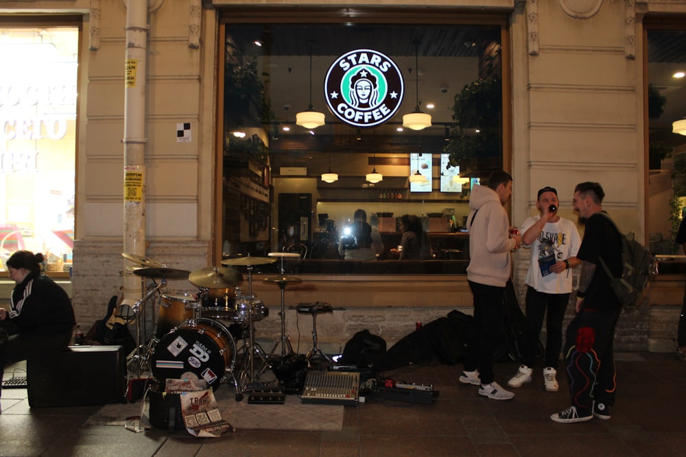 a group of people standing in front of a starbucks