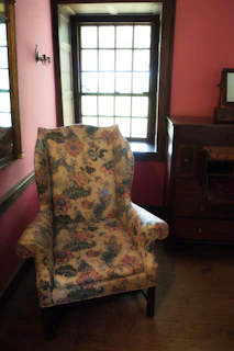 Stylish bedroom corner showcasing a vintage dresser and a comfortable armchair.