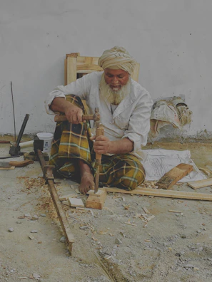 Portrait of an elderly craftsman smiling softly, surrounded by his handcrafted mandar drums.