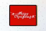 A sleek tablet showing a holiday-themed tech gift guide on its vibrant screen.