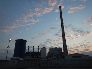 Wide-angle view of a sprawling industrial site with massive steel structures under a dark sky.