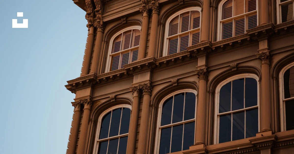 Clock Windows Building A building with many windows and a clock on the side of it photo – Free ...
