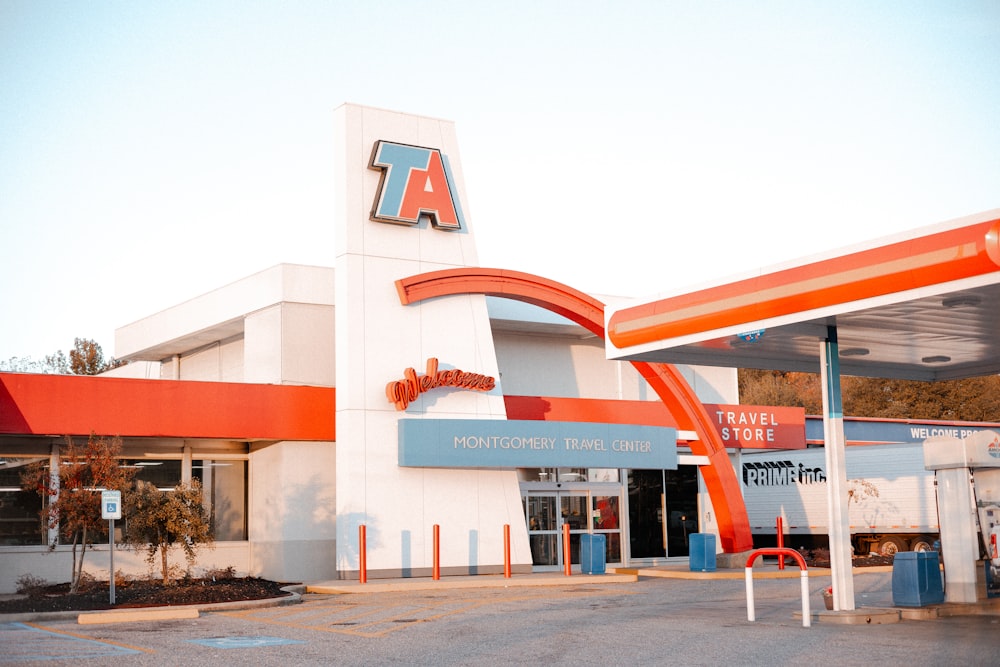 a gas station with a large orange and white awning