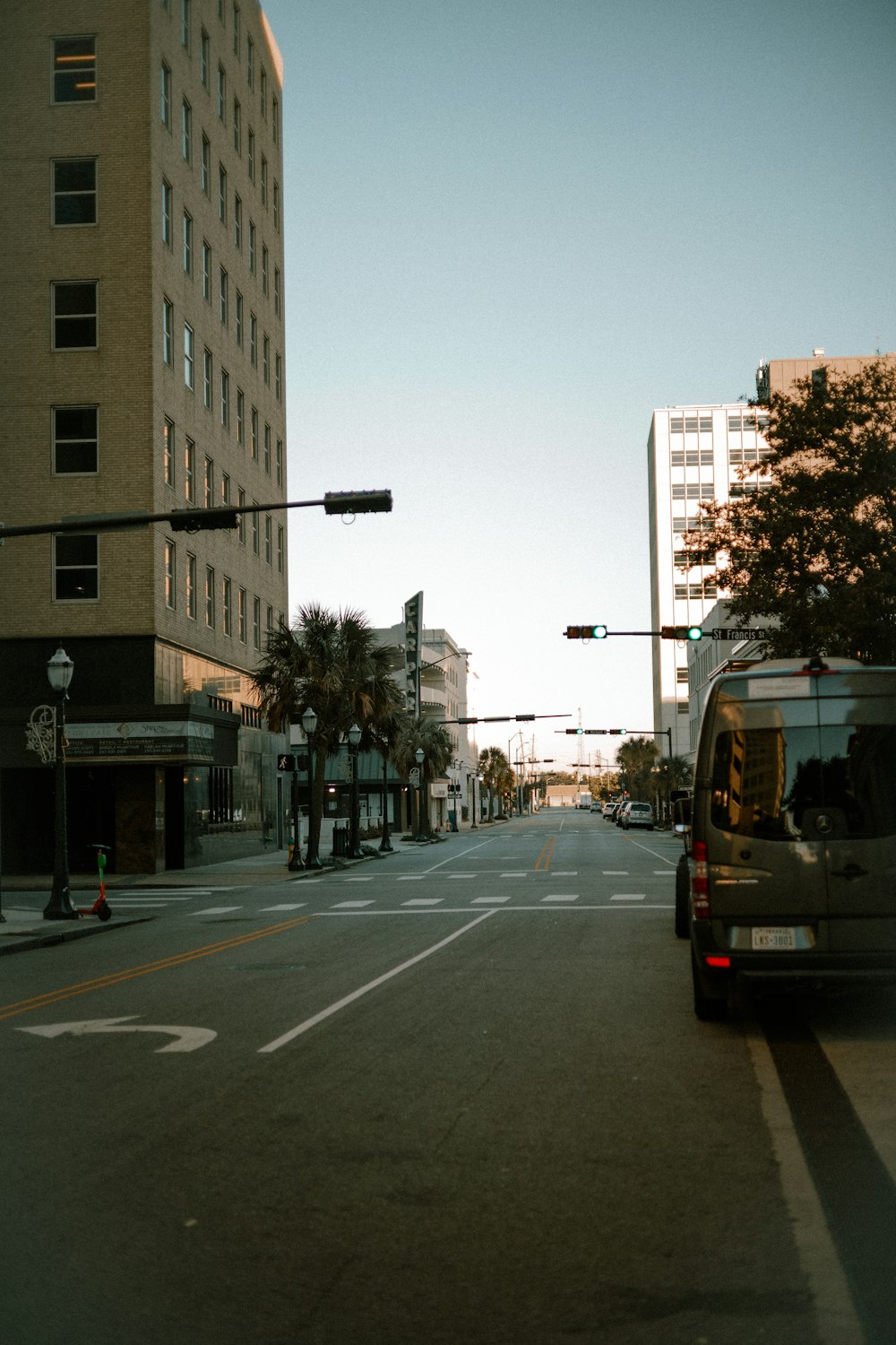 a van driving down a street next to tall buildings