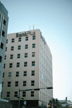 a large white building with a bank plus sign on top of it