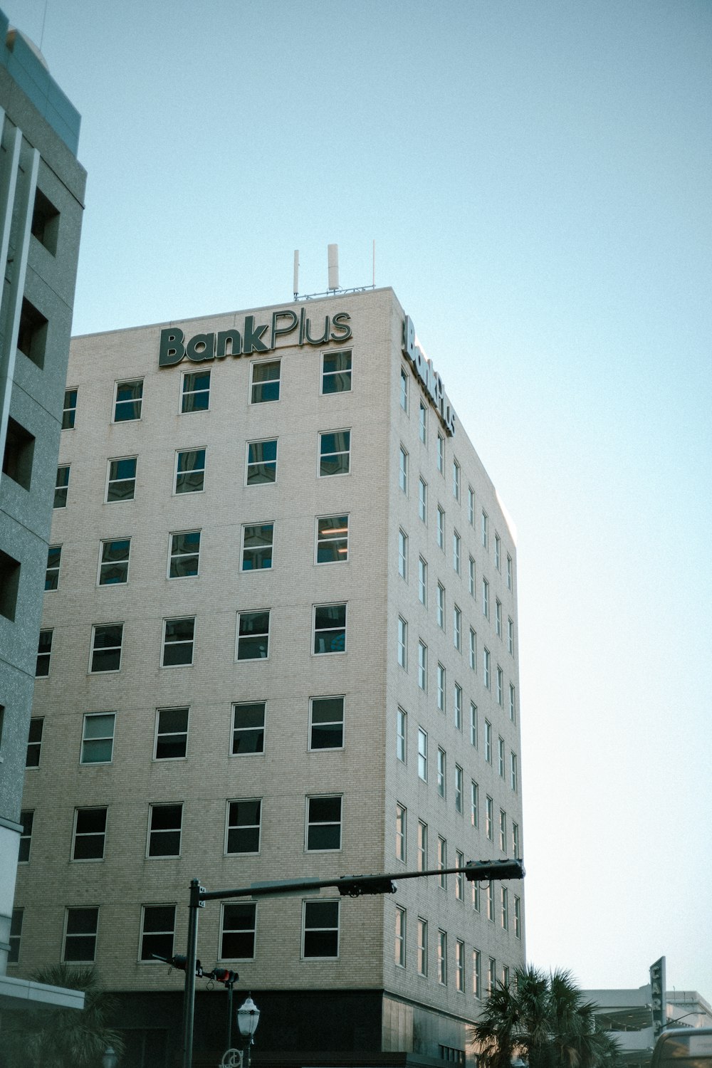 a large white building with a bank plus sign on top of it