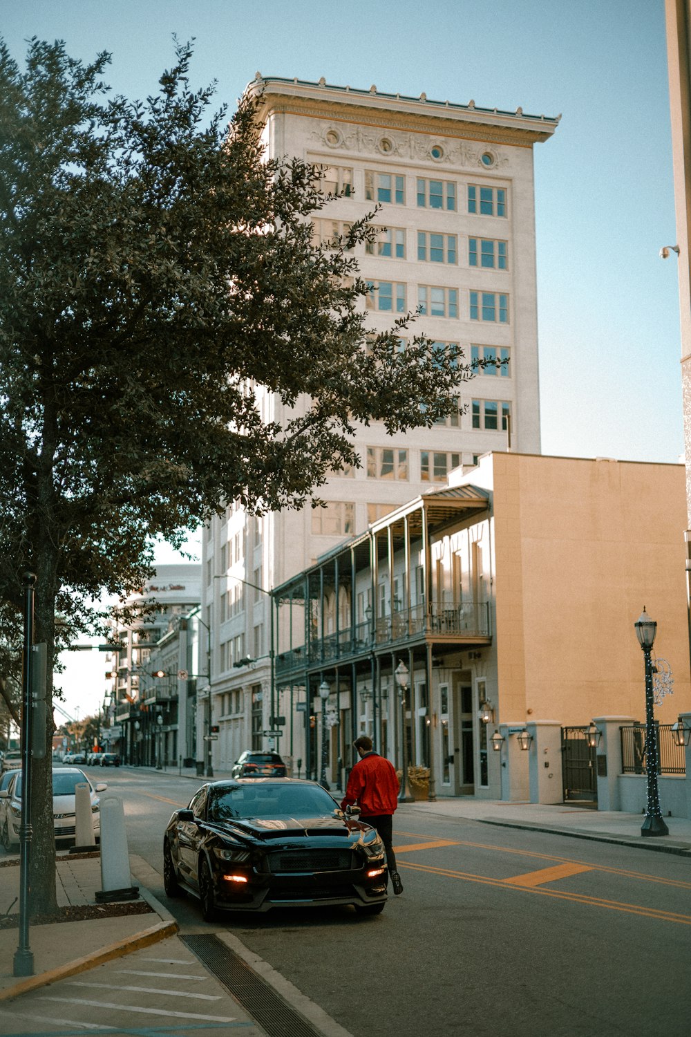 a car parked on the side of a street next to a tall building