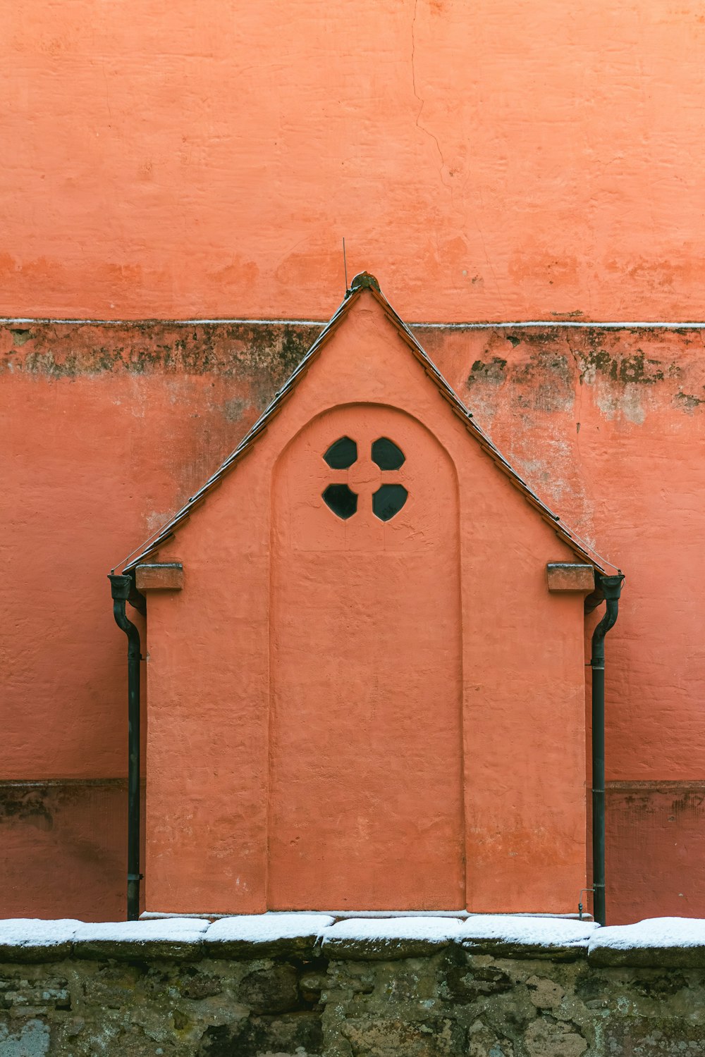 a red building with a window and a clock