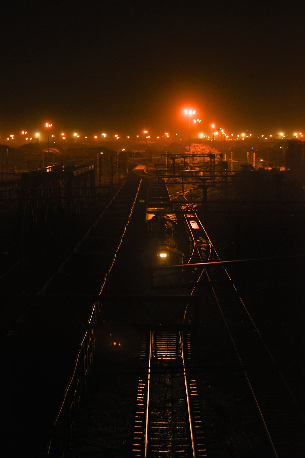 a train traveling down train tracks at night