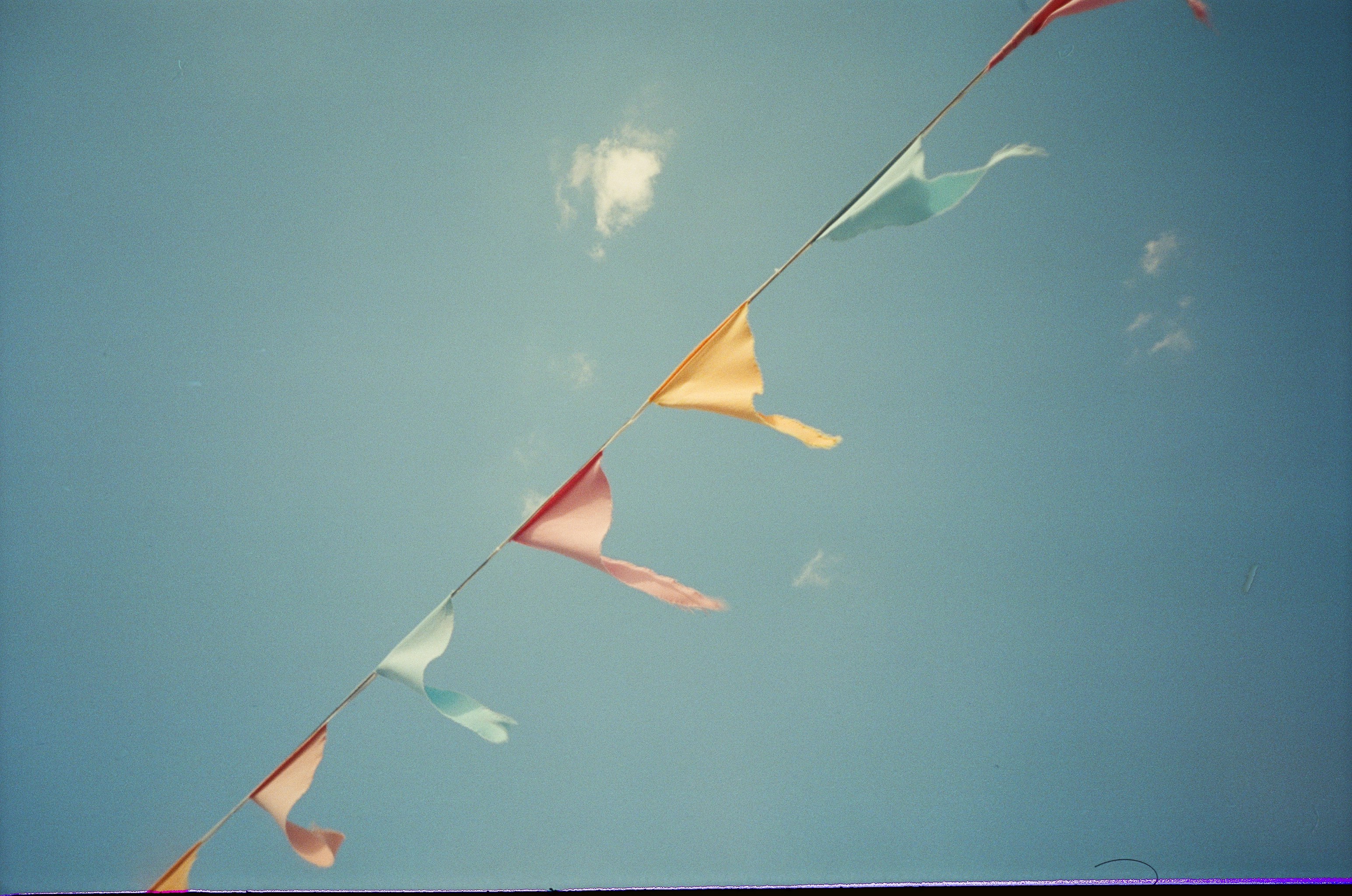 Bunting and flags strung overhead, moving in the wind against a clear sky