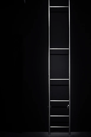 An industrial aluminium ladder set against a warehouse backdrop, showcasing its heavy-duty build.