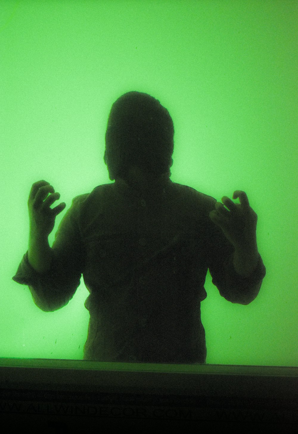 a person standing in front of a green wall
