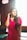 a woman in a red dress talking on a cell phone