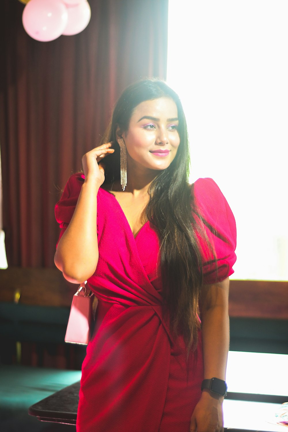 a woman in a red dress talking on a cell phone