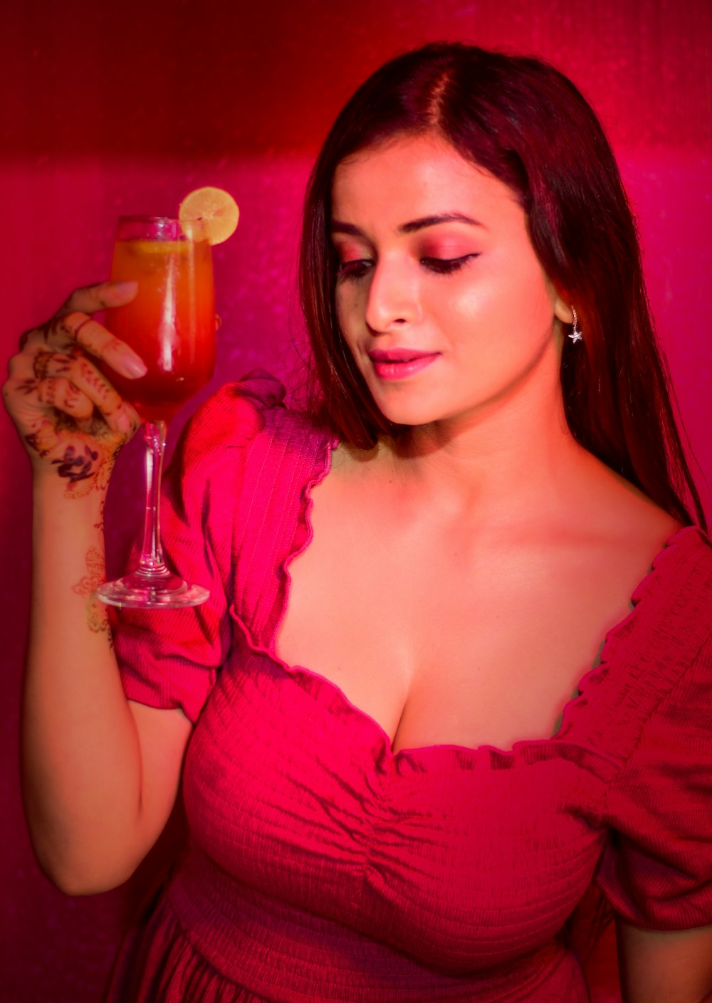 a woman in a red dress holding a drink