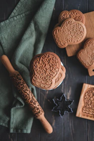 Artisanal cookie cutters arranged neatly on a cream textured background.
