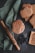 A collection of intricately patterned cookies is displayed alongside a decorative rolling pin and wooden molds. The cookies have a textured, floral design, and are placed on a rustic wooden surface. A green cloth is draped beneath the items, adding a touch of color. A star-shaped cookie cutter and wooden cutting board complete the cozy baking scene.