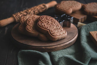 Close-up of a variety of handcrafted cookies arranged on rustic wooden board.