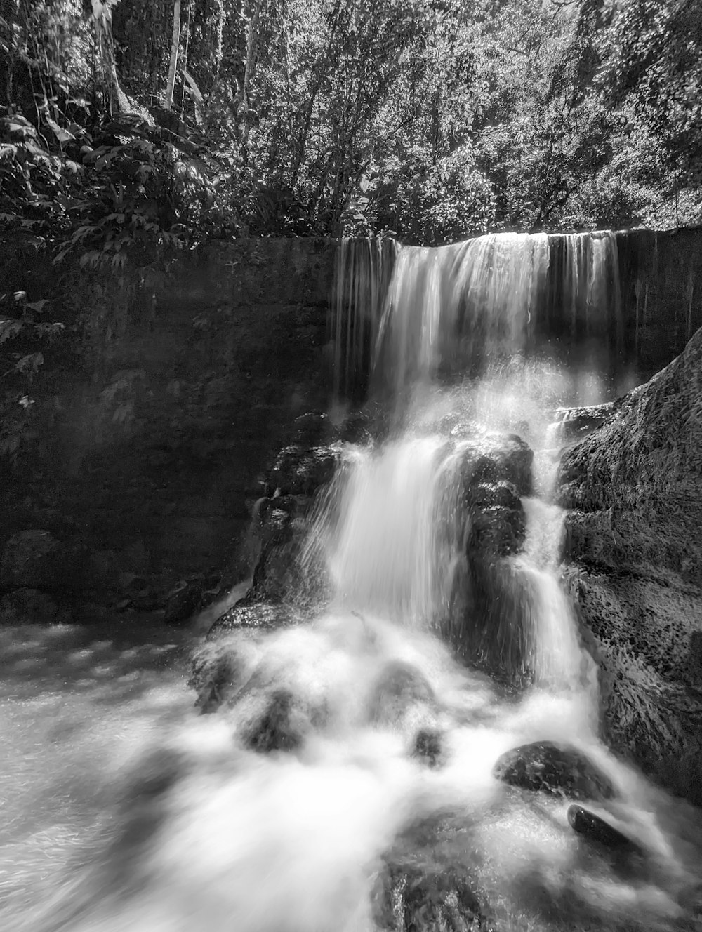 a black and white photo of a waterfall