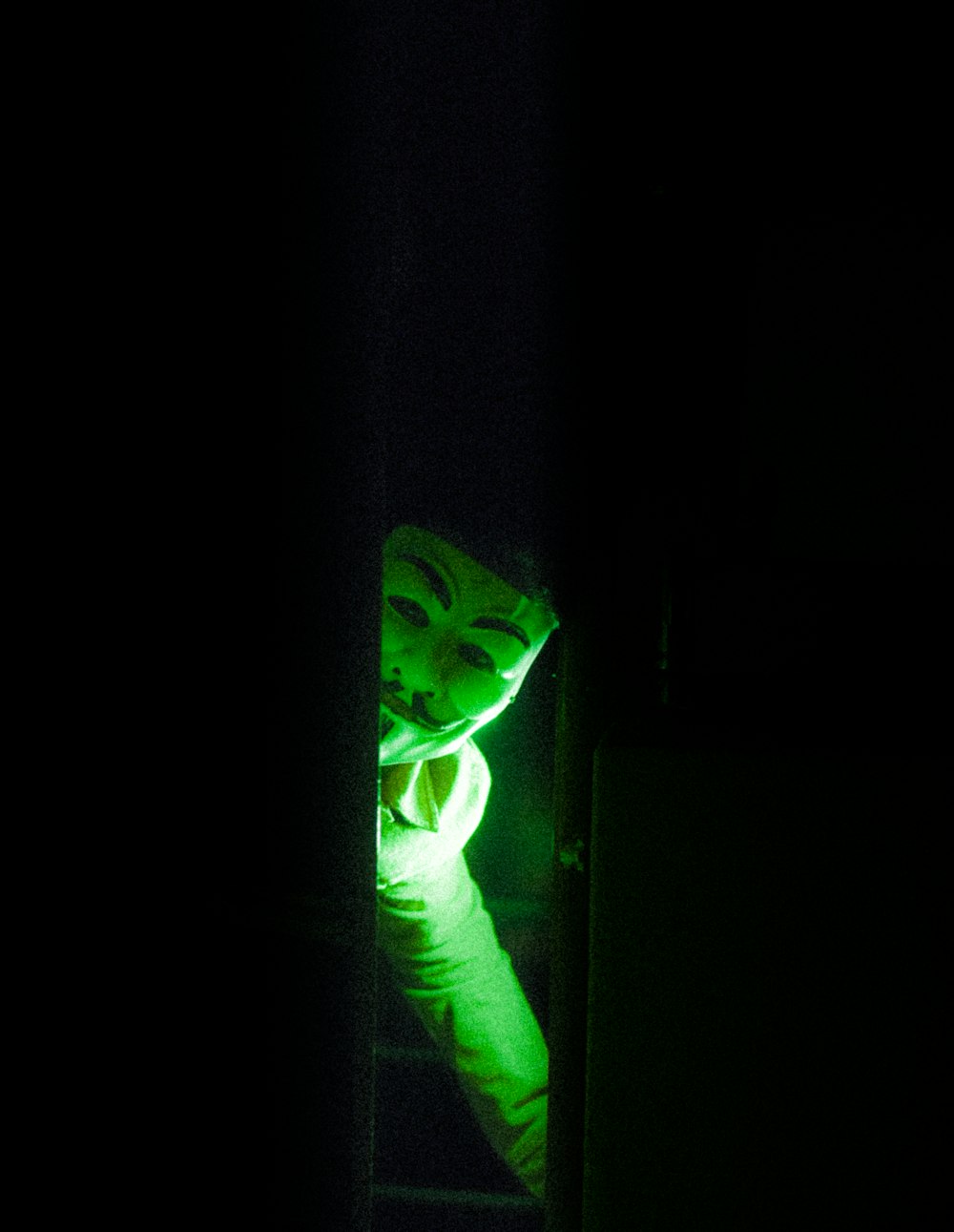 a person in a dark room with a green light