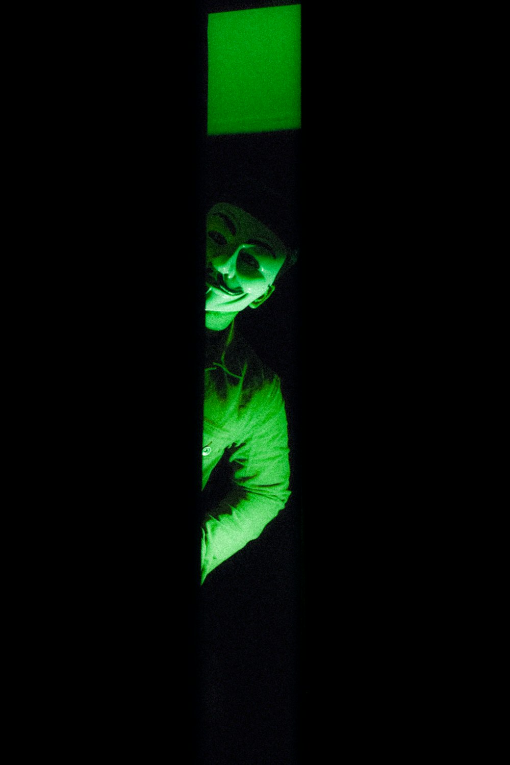 a person in a dark room with a green light